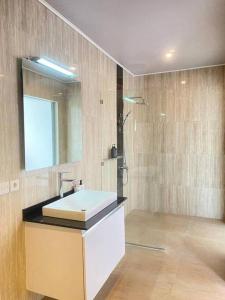 a bathroom with a sink and a mirror and a shower at Villa Akmali Umalas 2BR with Private Pool & Jacuzzi in Canggu