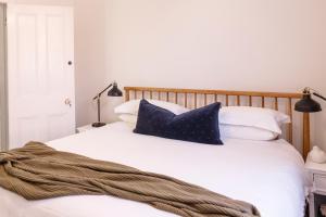 a bed with blue and white pillows on it at Hazel House Boutique Heritage Stay in Central Goulburn in Goulburn