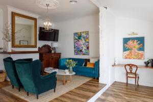 a living room with a blue couch and a table at Hazel House Boutique Heritage Stay in Central Goulburn in Goulburn