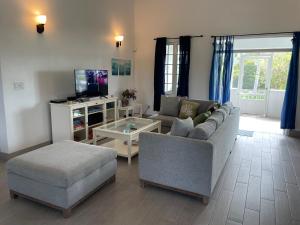 ein Wohnzimmer mit einem Sofa und einem Tisch in der Unterkunft 2 Bed 2bath Cottage Pickleball Court Pool in Providenciales