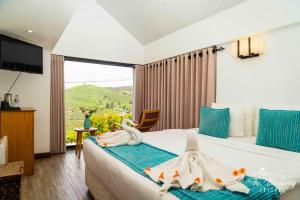 a hotel room with a bed with towels on it at The Blackberry Cottage in Nuwara Eliya