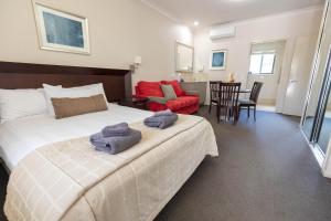 Highfields Motel Toowoomba في Highfields: غرفة نوم عليها سرير وفوط