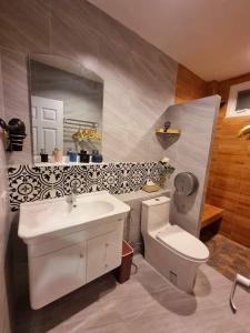 een badkamer met een wastafel, een toilet en een spiegel bij Green Home Pool Villa Hua Hin in Ban Wang Bot