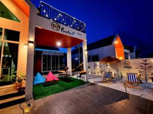 een hotel met een patio met stoelen en een parasol bij Green Home Pool Villa Hua Hin in Ban Wang Bot