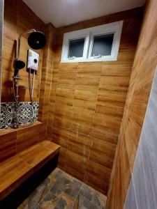 een badkamer met een douche, houten wanden en een raam bij Green Home Pool Villa Hua Hin in Ban Wang Bot