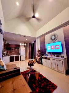 a living room with a couch and a tv and a kitchen at Green Home Pool Villa Hua Hin in Ban Wang Bot