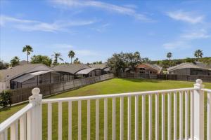 a white fence in front of a yard with houses at 4 Bedrooms 35 Bathrooms Lake Berkley 938 Pt in Kissimmee