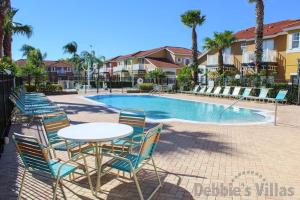 a table and chairs next to a swimming pool at 4 Bedrooms 35 Bathrooms Lake Berkley 938 Pt in Kissimmee