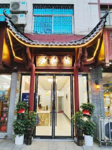 uma loja em frente a um edifício com um telhado chinês em 张家界大庸家民宿DYJ Hostel em Zhangjiajie