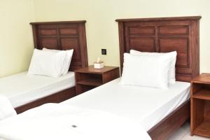 2 łóżka w pokoju z drewnianymi zagłówkami w obiekcie Kaliningrad Cottage w mieście Sidomukti
