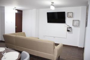 a living room with a couch and a flat screen tv at Departamento en Chiclayo Peru Las Brisas de Cix in Chiclayo