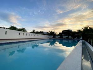 a large swimming pool with blue water in front of a building at Beach House Retreat in Argao in Argao