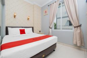 een slaapkamer met een groot bed en een raam bij RedDoorz Plus @ Cideng Barat in Jakarta