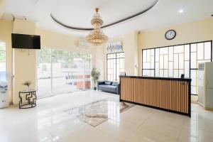 a living room with a large lobby with a clock at Sans Vibes Flamenco Hotel in Jakarta