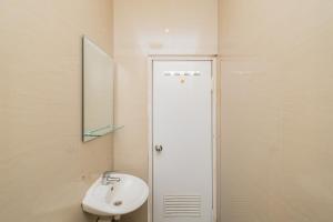 een badkamer met een wastafel en een spiegel bij RedDoorz Plus @ Cideng Barat in Jakarta