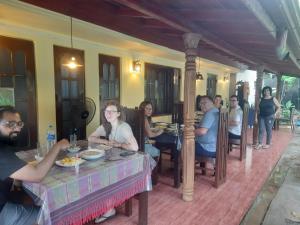 坦加拉的住宿－Sea Bay Inn Tangalle，坐在桌子上的一群人