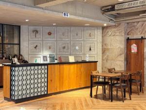 a restaurant with a counter and tables and chairs at Roaders Hotel Tainan ChengDa in Tainan