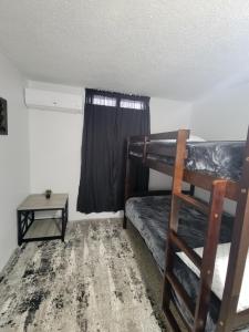 a room with two bunk beds and a table at Black and white vacation home in Ceiba