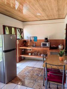 a kitchen with a stainless steel refrigerator and a table at Casa Victoria in Puntarenas