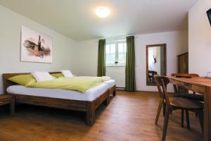 a bedroom with a bed and a table and a desk at Bierhotel Ranklleiten Almtal in Pettenbach