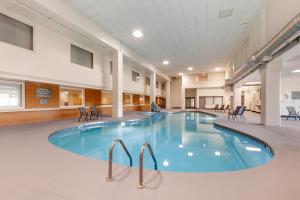 a pool in the middle of a building with chairs at Comfort Inn & Suites in Beaver Dam