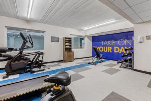 siłownia ze sprzętem do ćwiczeń wysiłkowych i znakiem na dzień w obiekcie Comfort Inn & Suites w mieście Beaver Dam