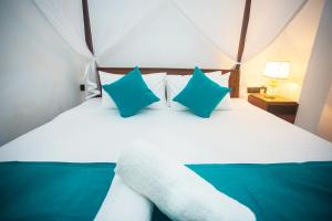 a bedroom with a bed with blue and white pillows at Villa Greenjay Ahangama in Ahangama