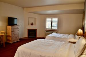 a hotel room with two beds and a television at Anaco Bay Inn in Anacortes