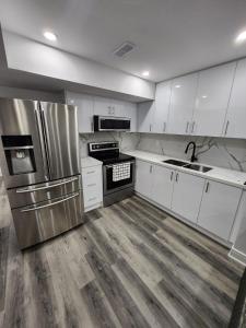 eine Küche mit weißen Schränken und einem Kühlschrank aus Edelstahl in der Unterkunft New Modern room in Innisfil in Innisfil