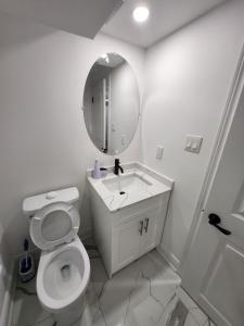 InnisfilにあるNew Modern room in Innisfilの白いバスルーム(トイレ、鏡付)
