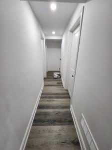 einen Flur mit weißen Wänden und Holzböden in der Unterkunft New Modern room in Innisfil in Innisfil