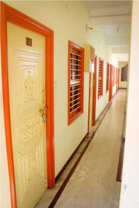 an empty hallway with a white door and a hallwayngth at PMS INN in Puducherry