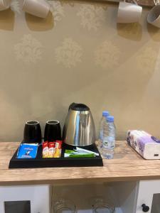 a counter with a coffee pot and water bottles on it at دار هند شقق مفروشة بحي سكني in Al Madinah