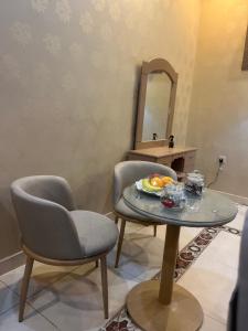 a room with a table and a chair and a mirror at دار هند شقق مفروشة بحي سكني in Al Madinah