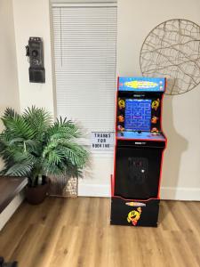 a video game machine in a room with a plant at Downtown Home - Close to Topgolf, Ravens Stadium, Orioles Park, UM Baltimore in Baltimore