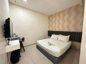 Dormitorio pequeño con cama y TV en WF Motel, en Kulim
