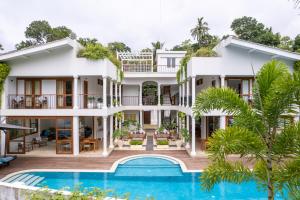 an exterior view of a villa with a swimming pool at Ginger Palm Villa in Hiriketiya