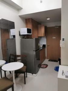 a kitchen with a refrigerator and a table and chairs at Good Day staycation shore 3 in Manila
