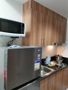 a kitchen with a microwave and a sink at Good Day staycation shore 3 in Manila