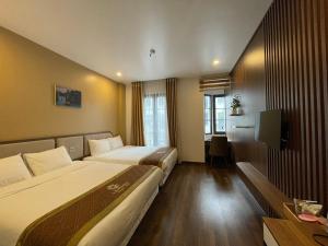 um quarto de hotel com duas camas e uma televisão em LANTANA Hạ Long Hotel E409 SUNPLAZA Phố đi bộ, Bãi Cháy, Hạ Long em Ha Long