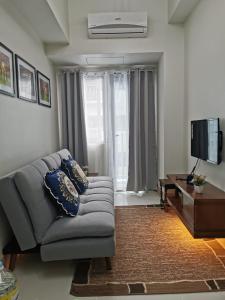 a living room with a couch and a television at Good Day staycation shore 3 in Manila