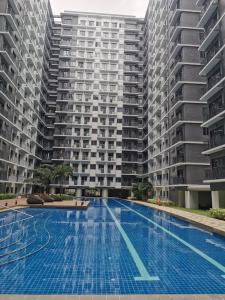 an empty swimming pool in front of two tall buildings at Good Day staycation shore 3 in Manila
