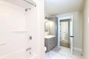 Baño blanco con bañera y lavamanos en Luxury Room in a House., en Moncton