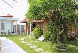 ein Haus mit einem Baum im Hof in der Unterkunft Green Village Jungle Resort in Nusa Penida