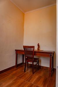 una sedia seduta di fronte a una scrivania in legno di PURI DIBIA HOTEL a Kuta