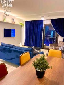 a living room with a table and a blue couch at UNIQue 2BRs LOCation l DOWNTown NEWCairo/City view in Cairo