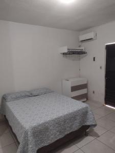 1 dormitorio con 1 cama en una habitación blanca en Conforto simples, en Maceió