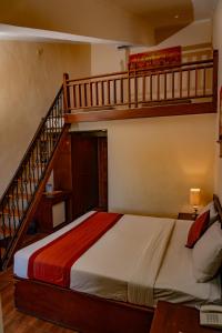 a bedroom with a bed and a staircase at PURI DIBIA HOTEL in Kuta