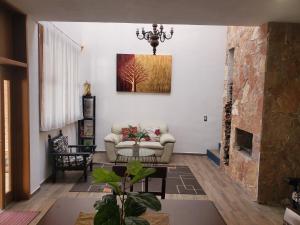 uma sala de estar com um sofá e uma lareira em Mini casa San José em Pénjamo