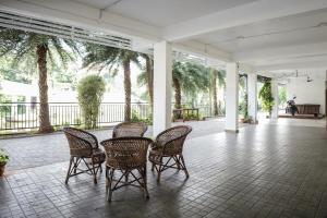 HOTEL LETS STAY في إرناكولام: مجموعة من الكراسي والطاولات على الفناء
